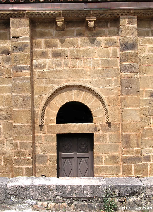 Puerta de la iglesia en el muro del sur. Aunque el guardapolvos es ajedrezado, típico del románico, se aprecia una simplicidad propia del prerrománico