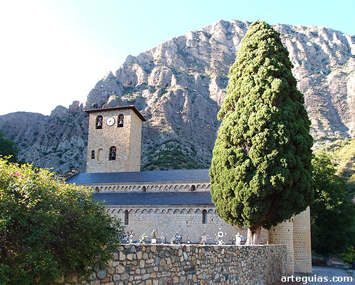 Conjunto de la iglesia del Monasterio de Alaón con las peñas del Prepirineo al fondo