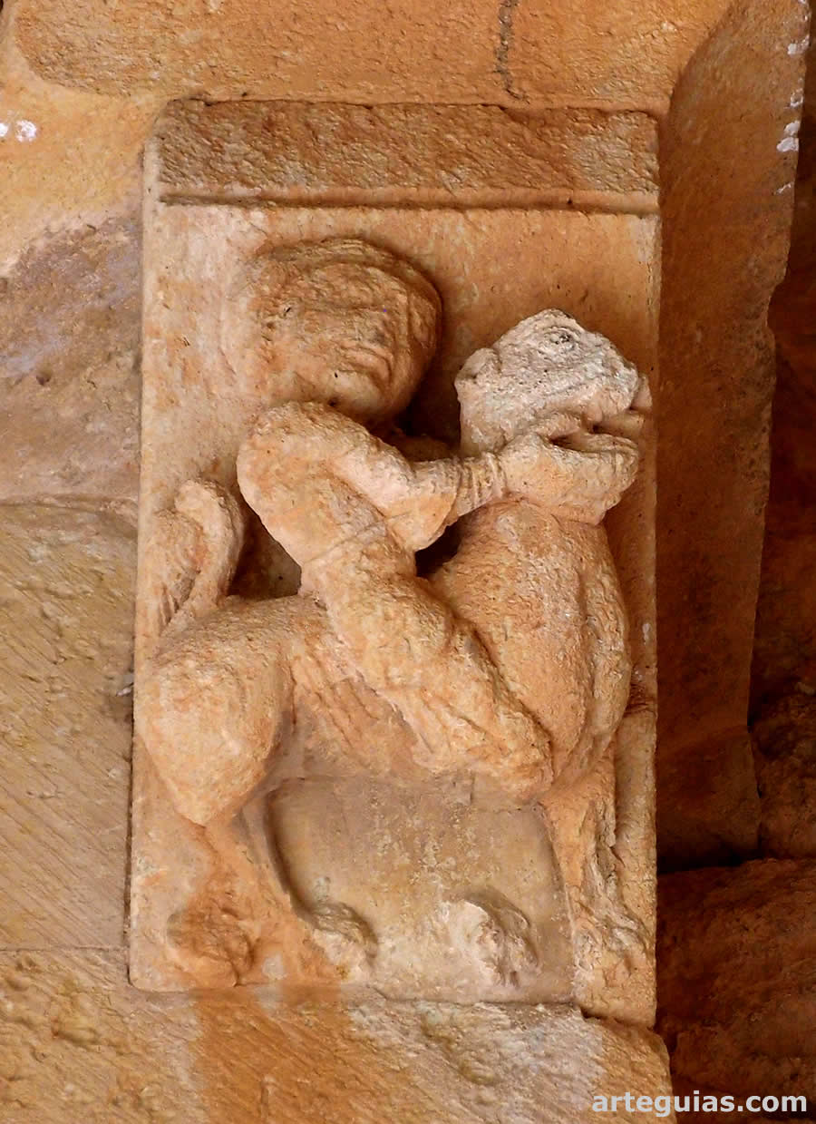 Canecillo del tajaroz de la puerta con un hombre matando a un león