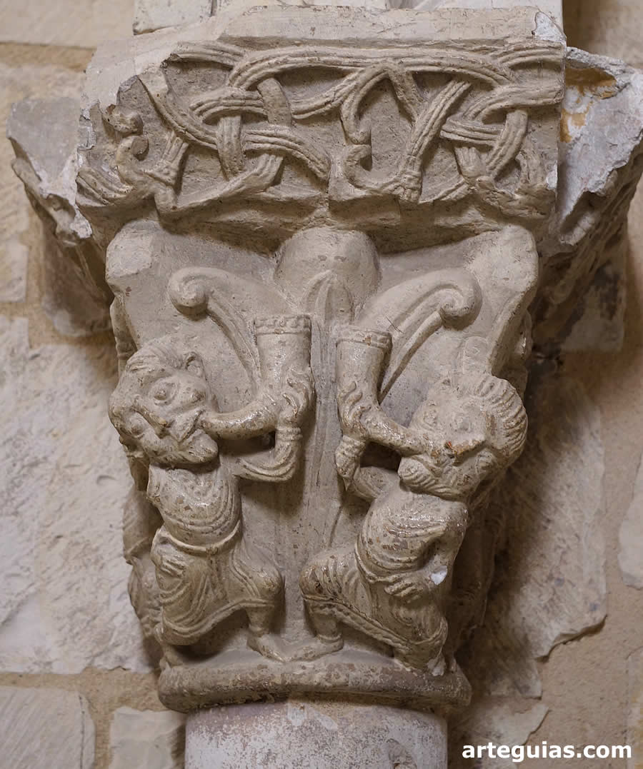 Capitel con dos hombre haciendo sonar dos cuernos