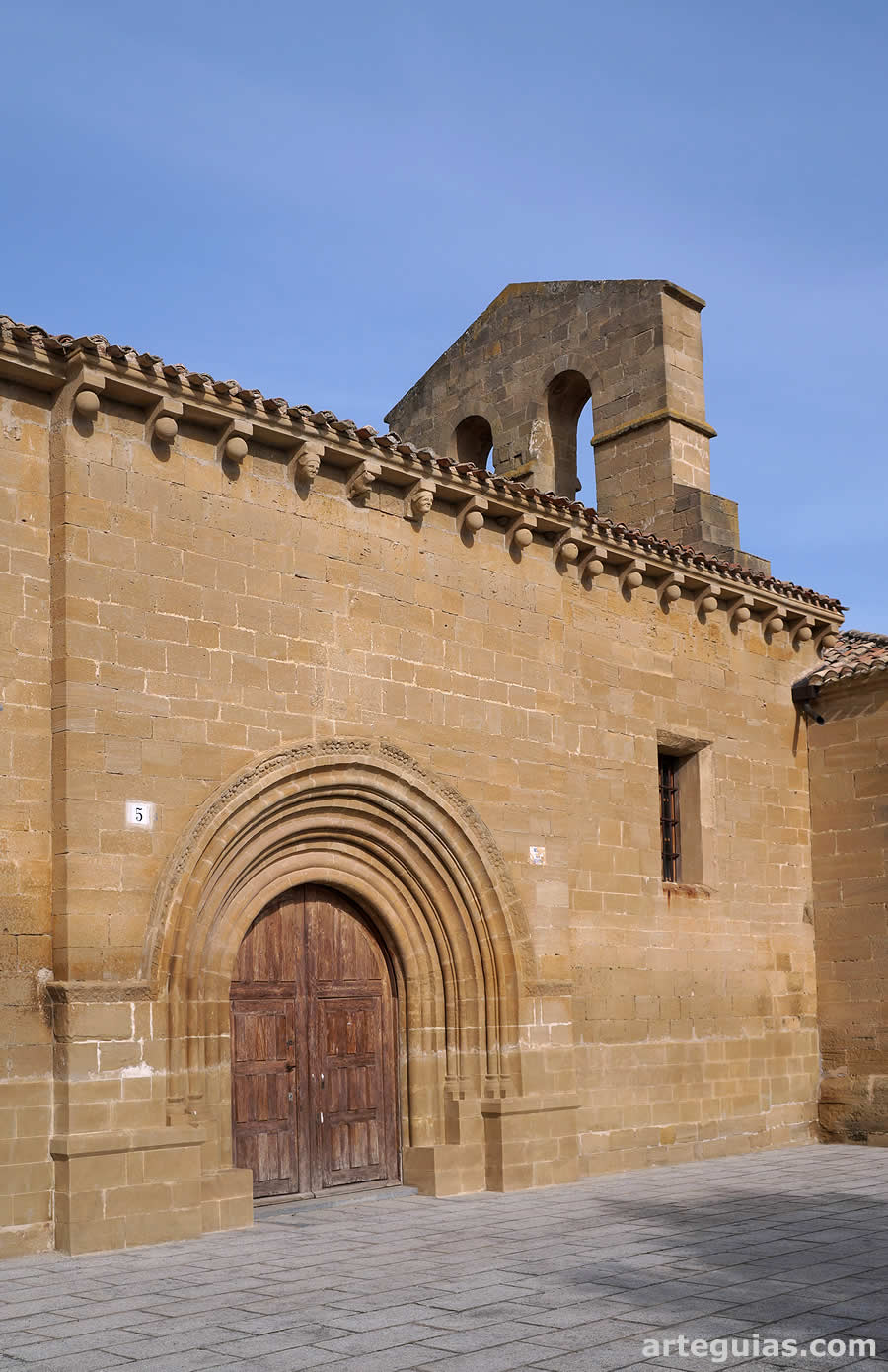 Iglesia de Tirgo, La Rioja: fachada meridional con la puerta y la espadaña