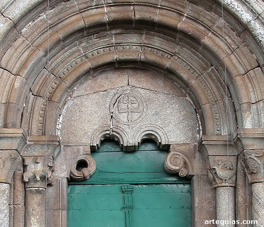 Detalle de esta puerta con el t&iacute;mpano y la cruz patriarcal