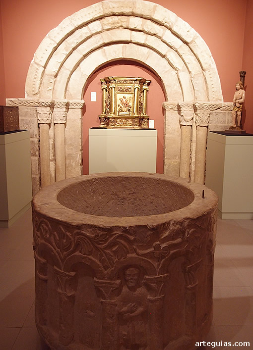 Una de las salas del Museo Diocesano de Sigüenza con una puerta y una pila románicas
